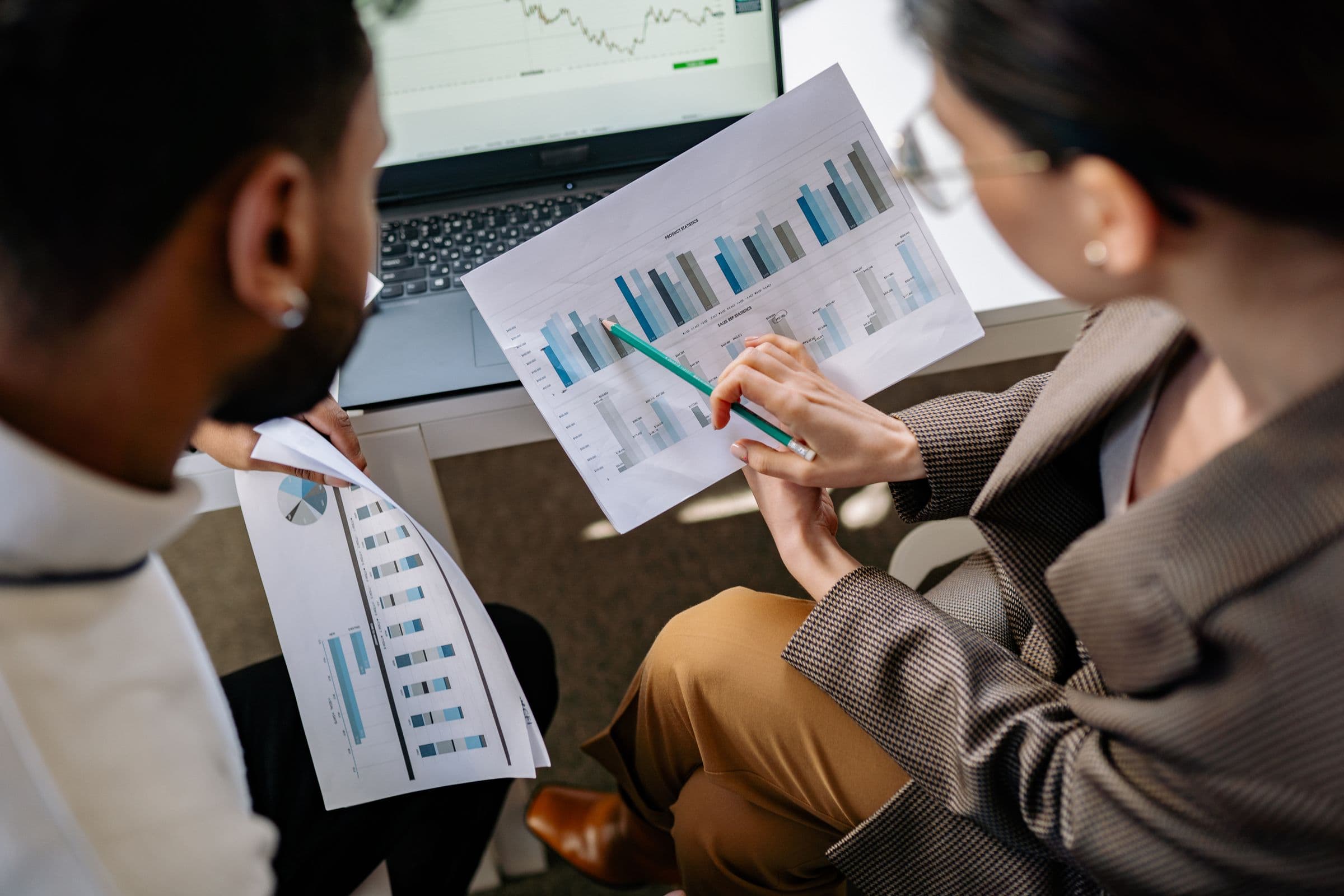 Two colleagues comparing printed performance charts